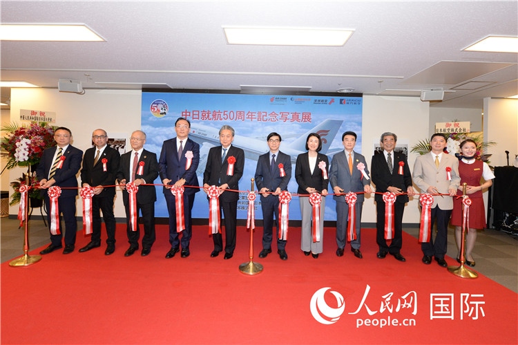 與會(huì)嘉賓共同為中日通航50周年紀(jì)念圖片展開(kāi)幕剪彩。馮學(xué)敏攝