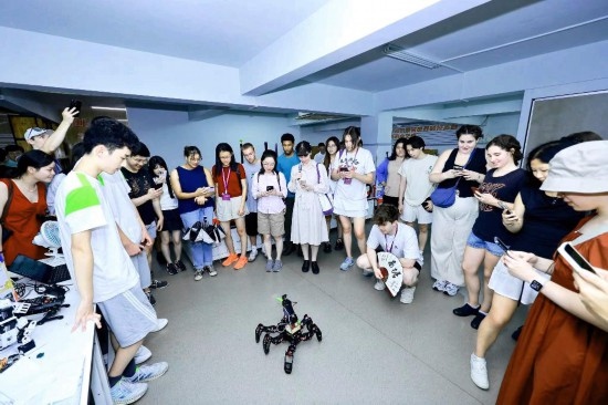 8月25日，中外青年在浙江杭州觀看機器人表演。新華社發(fā)（清華大學供圖）