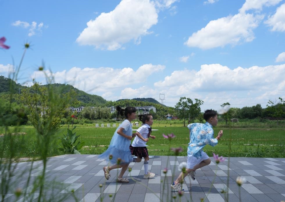 兒童在余姚市梁弄鎮(zhèn)的田野間奔跑（7月3日攝）。新華社記者翁忻旸 攝