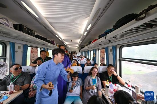9月7日，相聲演員在S910列車上為旅客表演快板。