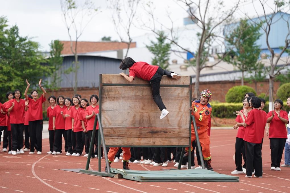 云南麗江華坪女子高級(jí)中學(xué)學(xué)生在體驗(yàn)翻越障礙板。新華社記者陳欣波 攝