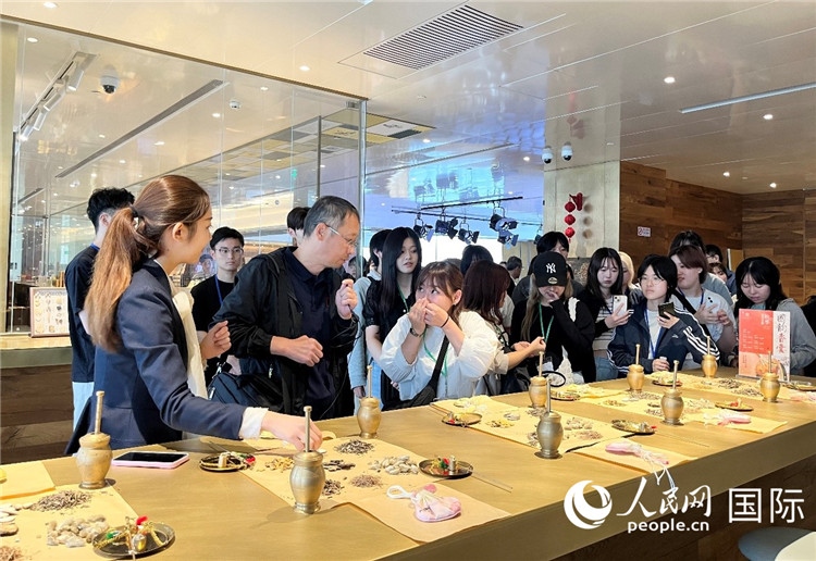 1. 日中友好協(xié)會(huì)青年代表團(tuán)一行學(xué)習(xí)中醫(yī)香囊制作工序。（人民網(wǎng)記者陳思 攝）