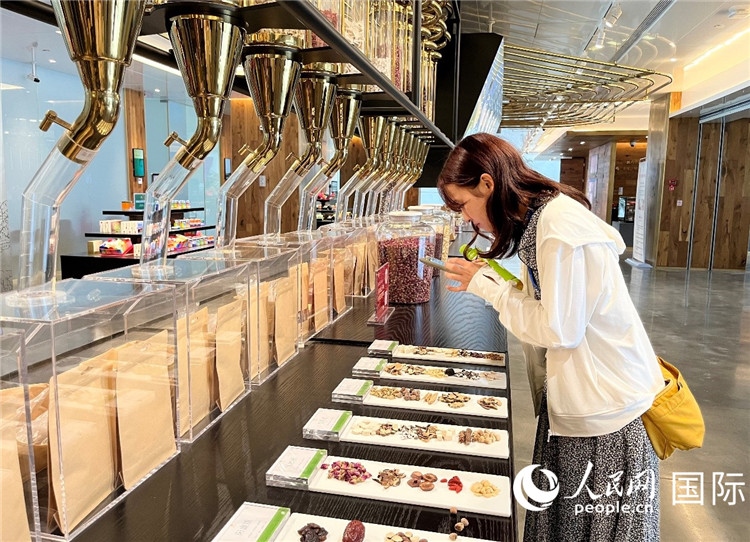 4. 代表團(tuán)團(tuán)員對(duì)新中式茶飲的食材充滿興趣。（人民網(wǎng)記者陳思 攝）