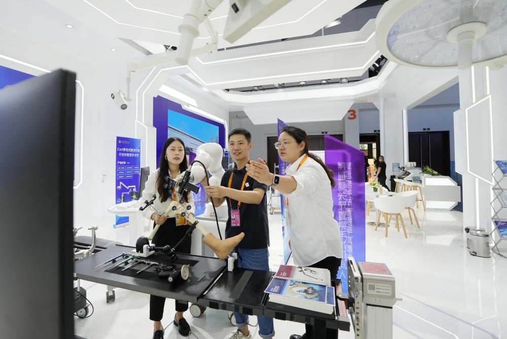 9月11日，一位媒體記者（中）在2024年服貿(mào)會(huì)國(guó)家會(huì)議中心會(huì)場(chǎng)體驗(yàn)北京納通科技集團(tuán)有限公司的膝關(guān)節(jié)置換手術(shù)機(jī)器人。新華社記者鞠煥宗 攝