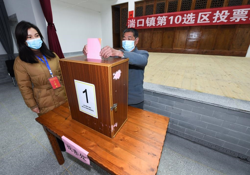 2021年12月14日，在浙江省杭州市臨安區(qū)湍口鎮(zhèn)迎豐村的基層投票點(diǎn)，村民在參加投票，村級監(jiān)察聯(lián)絡(luò)員監(jiān)票。新華社記者 徐昱 攝