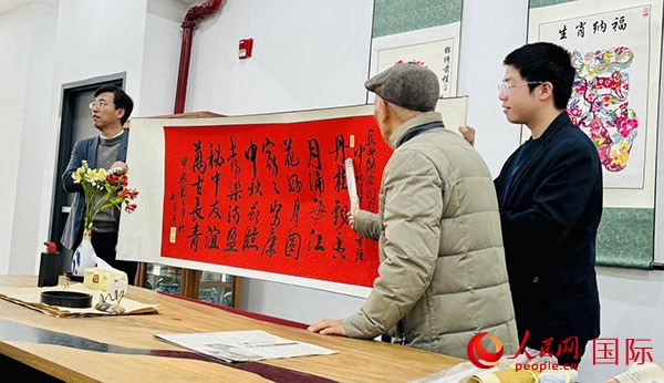 旅秘書(shū)法家向現(xiàn)場(chǎng)觀眾展示書(shū)法作品。人民網(wǎng)記者 宋亦然攝
