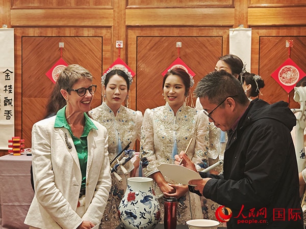 現(xiàn)場的非遺傳承人為英國觀眾展示畫技。人民網(wǎng)記者 邢雪攝