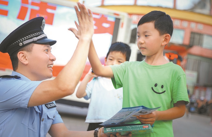 ▲7月10日，江西省吉安市公安局吉州分局組織民警深入轄區(qū)開展安全宣傳，民警向小朋友講解防溺水知識(shí)。朱文杰攝