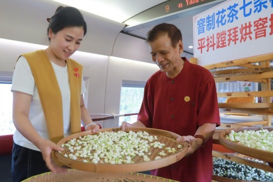 10月1日，福州市茉莉花茶窨制工藝代表性傳承人張子建與旅客在G1634次列車上制作茉莉花茶。新華社記者周義 攝