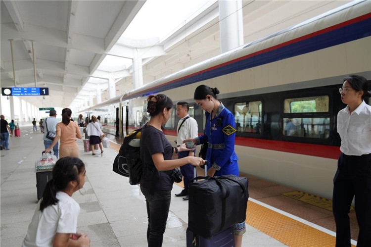 中老鐵路工作人員在站臺指引旅客進站乘車。老中鐵路有限公司供圖