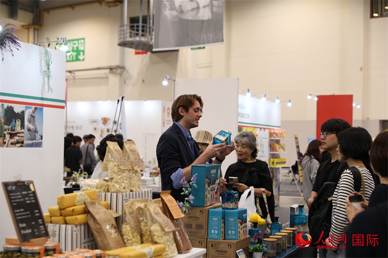 當?shù)貢r間10月5日，在第21屆釜山國際美食博覽會上，意大利展商向參觀者們介紹的意大利食品。人民網(wǎng)記者 莽九晨攝