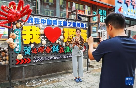 9月21日，游客在吉林省琿春市一處帝王蟹元素主題裝飾前拍照留念。新華社發(fā)