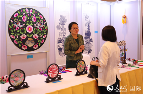 青海非遺文化傳承人向嘉賓介紹展品。人民網(wǎng)實(shí)習(xí)生姚欣可攝