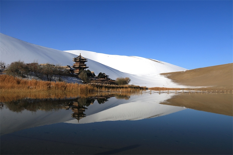 鳴沙山月牙泉景區(qū)雪景。敦煌市委宣傳部供圖，張曉亮攝