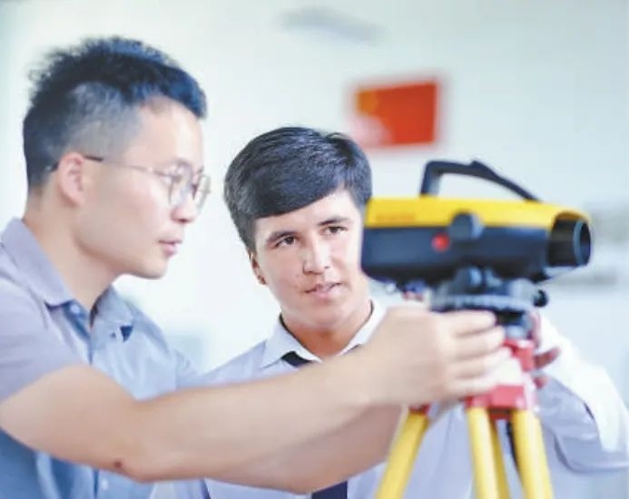 在塔吉克斯坦首都杜尚別的魯班工坊，來自天津城市建設管理職業(yè)技術學院的老師（左）為當地學生提供指導。新華社記者 鄭開君 攝