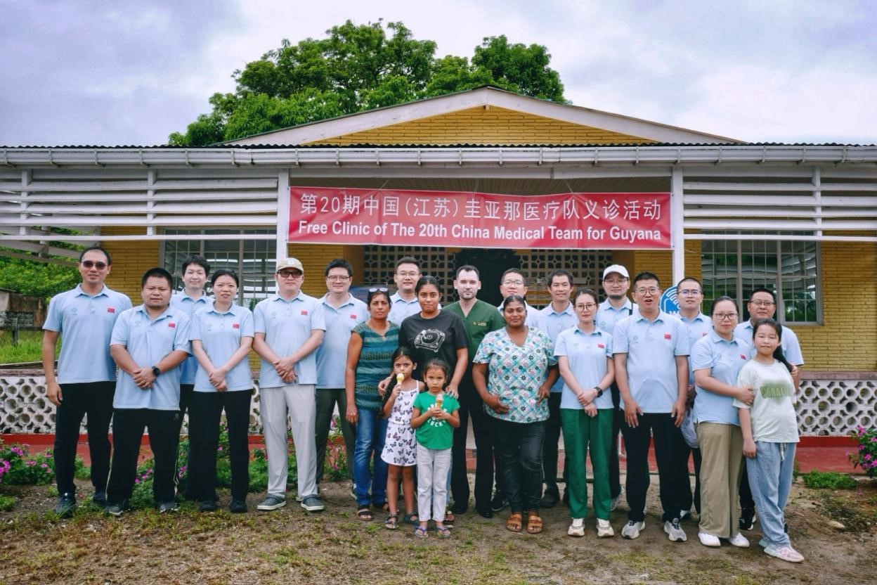 第20期中國（江蘇）援圭亞那醫(yī)療隊在圭偏遠的林登高速社區(qū)開展義診后，與部分當?shù)鼐用窈嫌啊?中國援圭醫(yī)療隊供圖