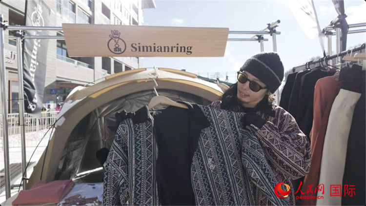 藤田周正在展示自己設(shè)計(jì)的滑雪服。人民網(wǎng)記者 袁蒙攝