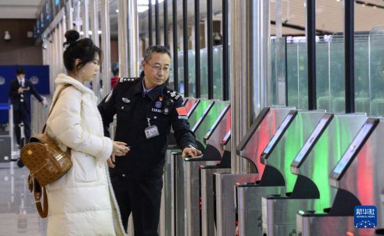 1月2日，大興機(jī)場邊檢站警察指導(dǎo)旅客使用自助出境設(shè)備。新華社記者 李欣 攝
