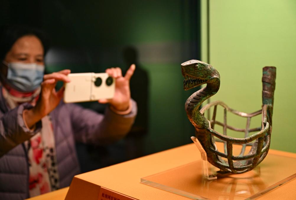 1月14日，觀眾在上海博物館蛇年迎春展拍攝展品蛇綱網(wǎng)狀銅器。新華社發(fā)（陳浩明攝）