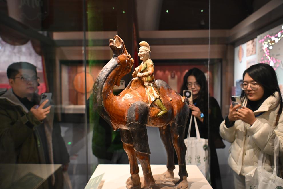 1月15日，觀眾在拍攝“長安三萬里——陜西唐代文物精華展”展出的三彩胡人騎駝俑。（新華社記者 孫凡越 攝）
