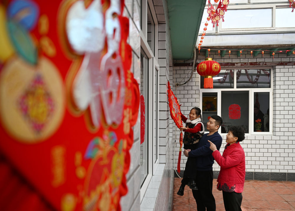 天津市西青區(qū)辛口鎮(zhèn)第六埠村村民在院子里掛“福”字（2024年2月1日攝）。新華社記者 趙子碩 攝