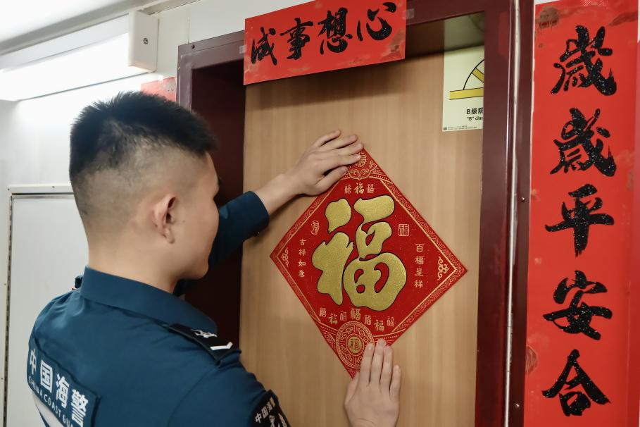 1月27日，在中國(guó)海警海鷗艦上，執(zhí)法員貼春聯(lián)福字慶祝農(nóng)歷春節(jié)。