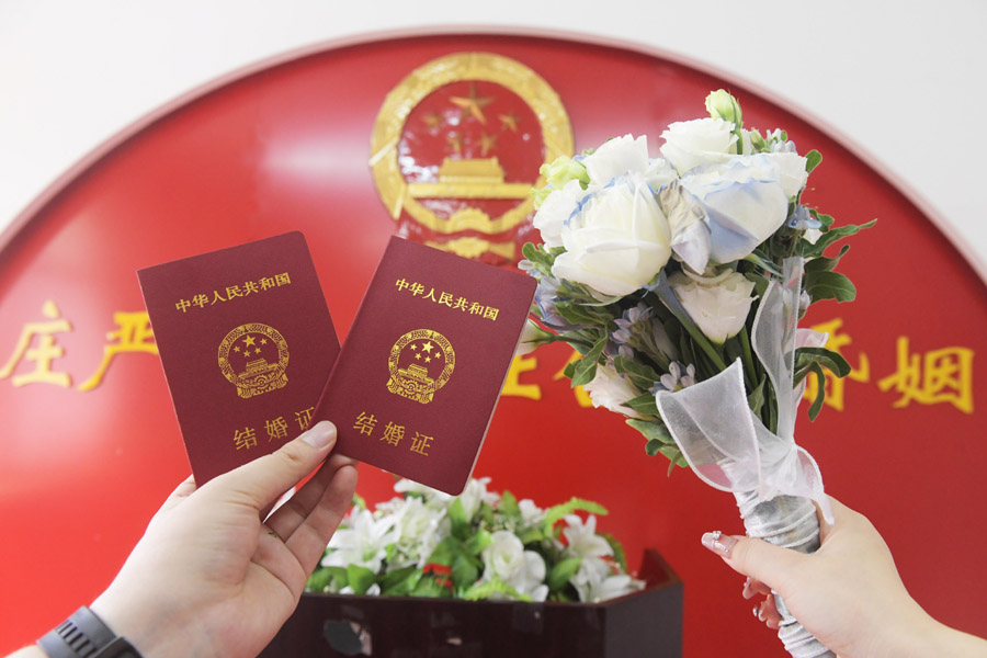 2024年8月10日，一對新人在河北石家莊新樂市民政局婚姻登記處領取結婚證后拍照留念。新華社發(fā)（賈敏杰攝）