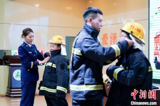 圖為學(xué)生們現(xiàn)場穿戴消防頭盔和戰(zhàn)斗服。中新社記者 趙宇航 攝