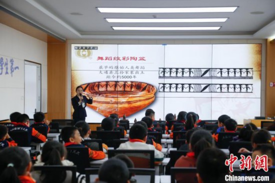 圖為學(xué)生在“國寶音樂會(huì)”社教課中了解舞蹈紋彩陶盆。中新社記者 馬銘言 攝