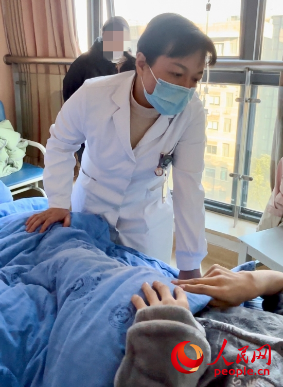鄧茜查房時(shí)詢問(wèn)患者情況。人民網(wǎng)記者 金慧慧攝