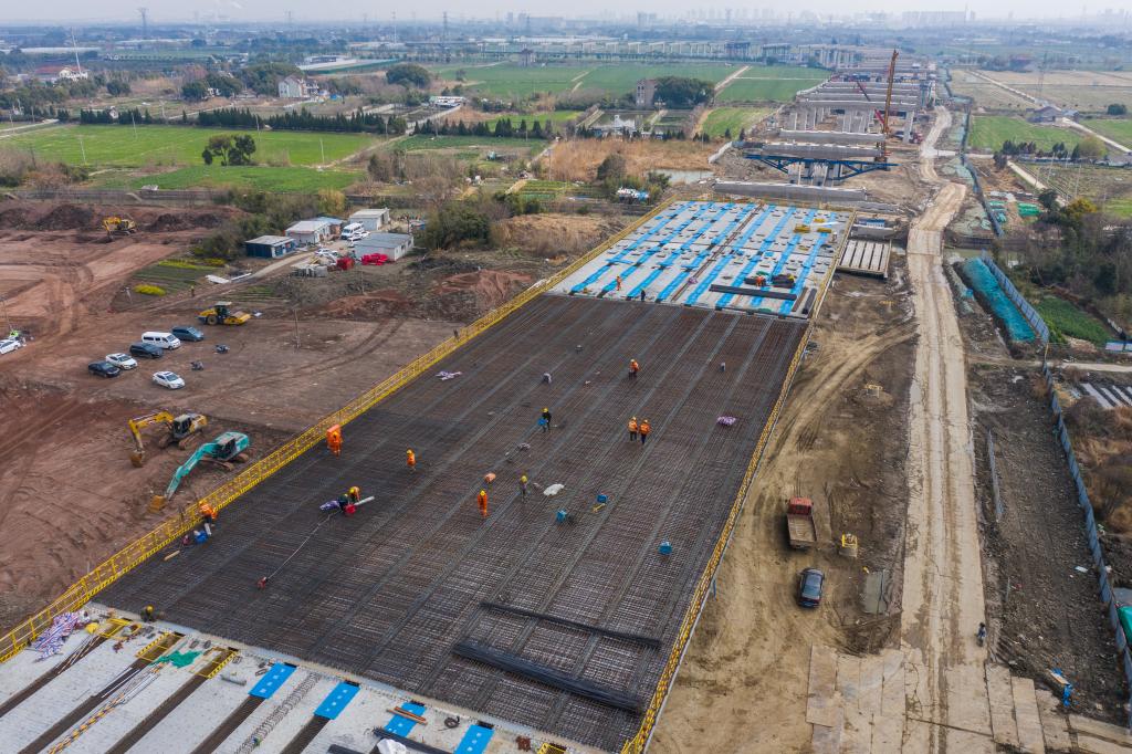 3月7日，在524國道秀洲王江涇至新塍公路工程TJ02標(biāo)段，作業(yè)人員正在進(jìn)行60米鋼混組合梁現(xiàn)澆橋面板鋼筋焊接及綁扎作業(yè)（無人機(jī)照片）。新華社記者 徐昱 攝