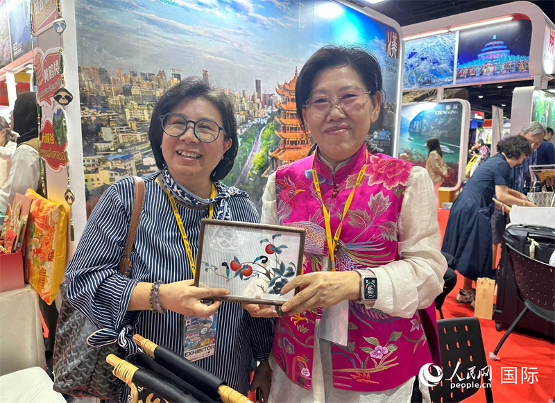 中國“大冶刺繡”傳承人劉小紅（右）參加泰國國際旅游展，向觀眾介紹中國非遺刺繡針法。人民網(wǎng)記者 簡承淵攝
