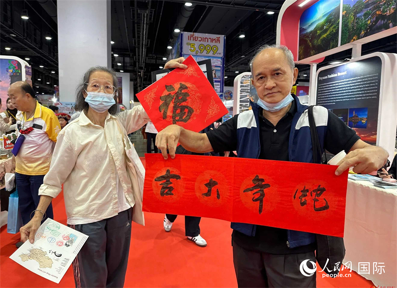2025蛇年春節(jié)，泰國市民展示他們領(lǐng)到的華人手寫春聯(lián)。人民網(wǎng)記者 簡承淵攝