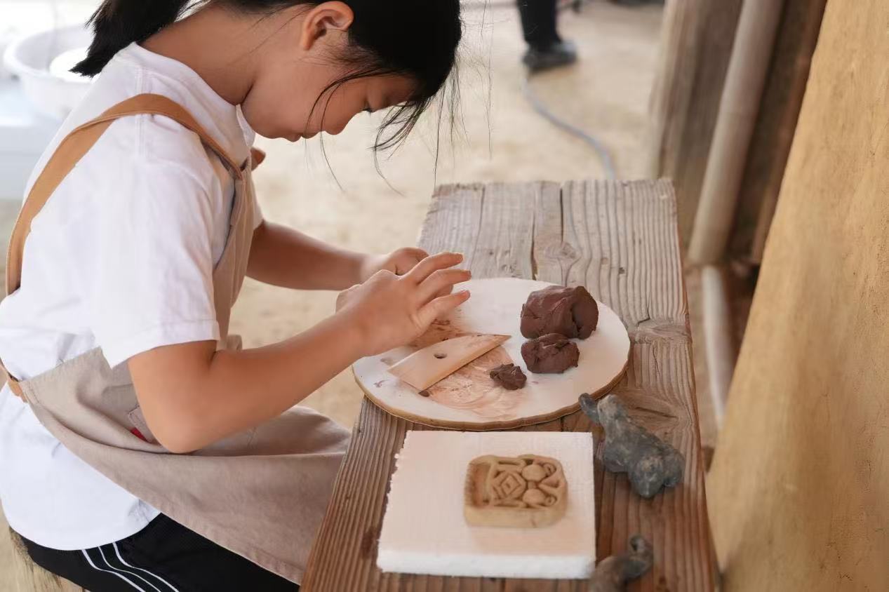 游客制作良渚特色陶藝品。良渚博物院供圖