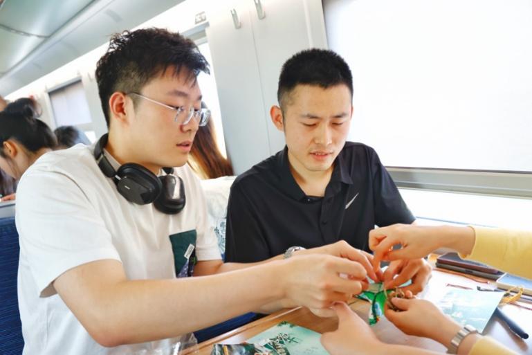 G232次旅客親手制作端午荷包和五彩繩。王磊攝
