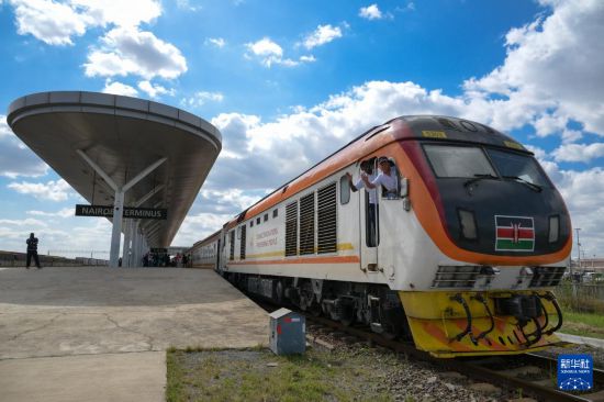 5月31日，在蒙內(nèi)鐵路內(nèi)羅畢站，機(jī)車(chē)駕駛員蔣立平（右）和博爾在即將開(kāi)往蒙巴薩的E2次列車(chē)上揮手致意。新華社記者 楊光 攝